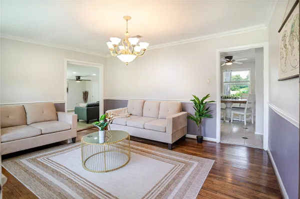 a living room with furniture potted plant and wooden floor