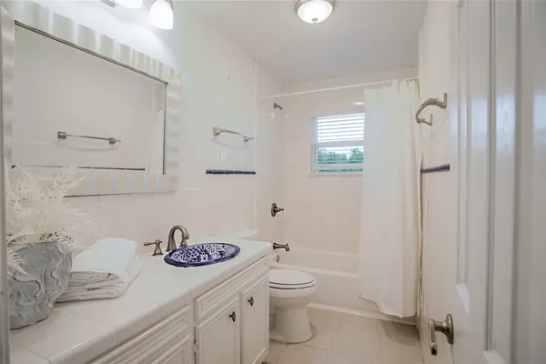 a bathroom with a granite countertop sink mirror vanity and toilet