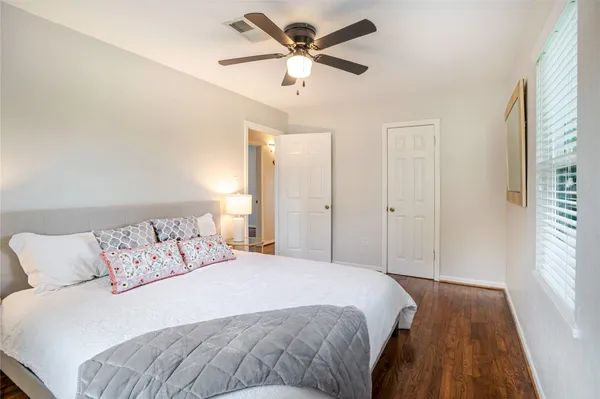 a bedroom with a large bed and a ceiling fan