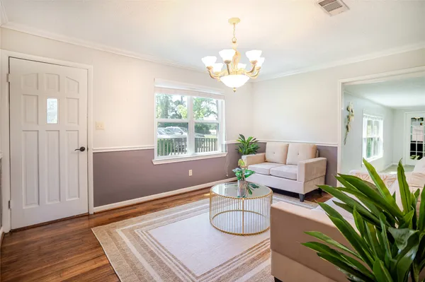 a living room with furniture a chandelier and a rug