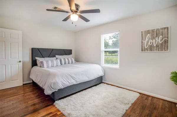 a bedroom with a bed and wooden floor