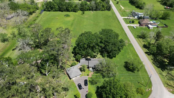 an aerial view of residential houses with outdoor space and trees