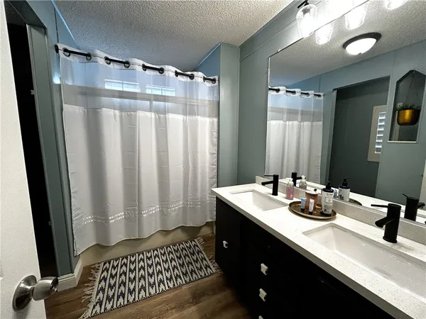 a bathroom with a sink a mirror and a shower