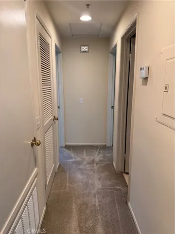 a view of a hallway with closet and wooden floor