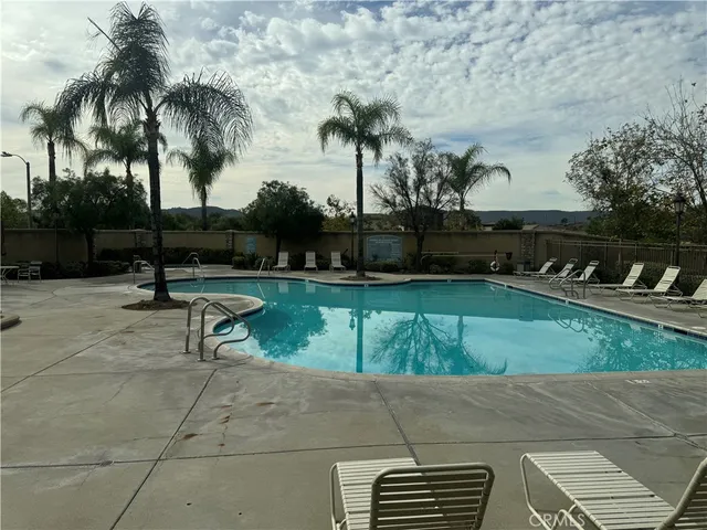 a swimming pool with outdoor seating and trees