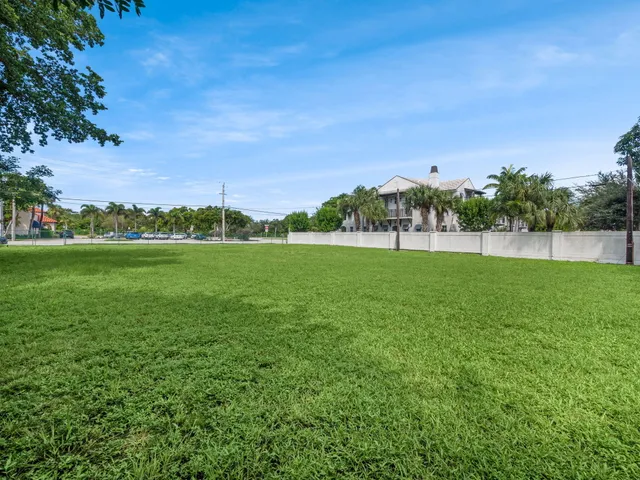 a view of yard with grass and a building in the background