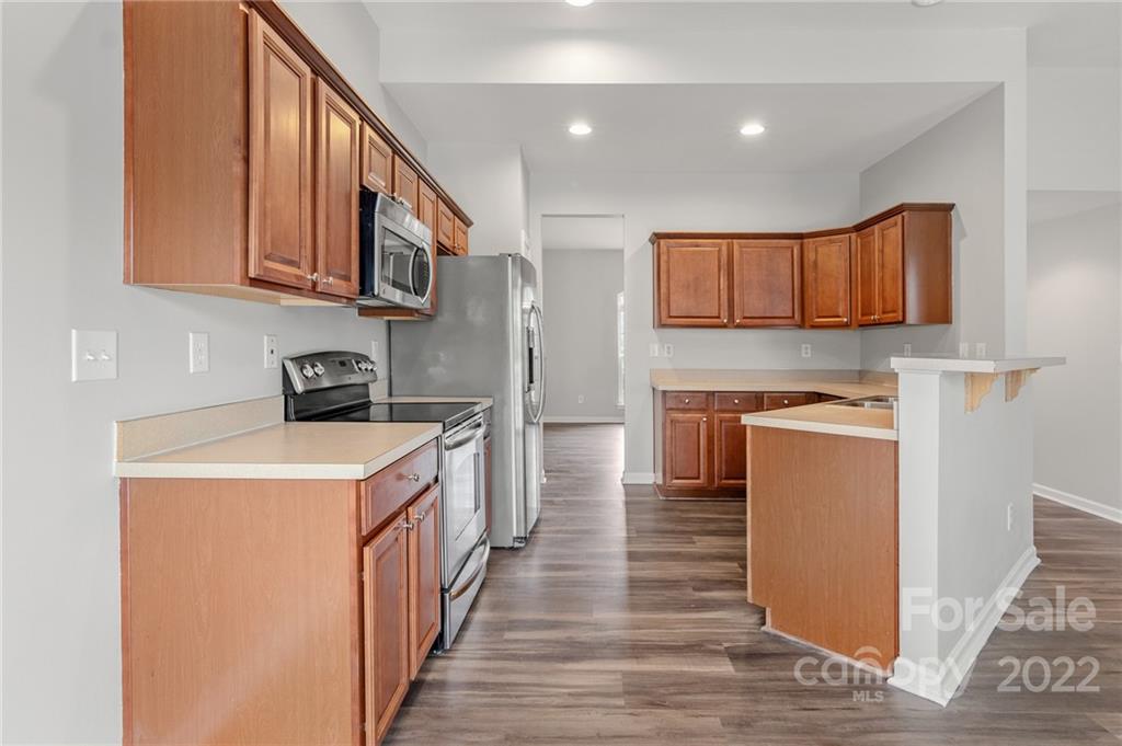 272 Lorraine Road Fort Mill, SC 29708 - Photo 14 of 42 a kitchen with stainless steel appliances granite countertop a refrigerator a stove top oven a sink and dishwasher with wooden floor