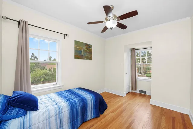 a bedroom with a bed and wooden floor