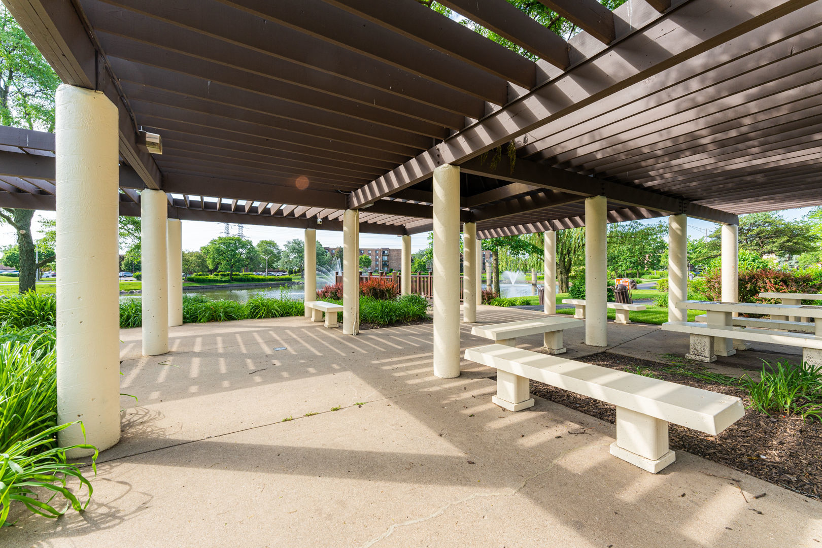 625 West Huntington Commons Road, Unit 106 Mount Prospect, IL 60056 - Photo 16 of 17 a view of a patio with a table and chairs under an umbrella