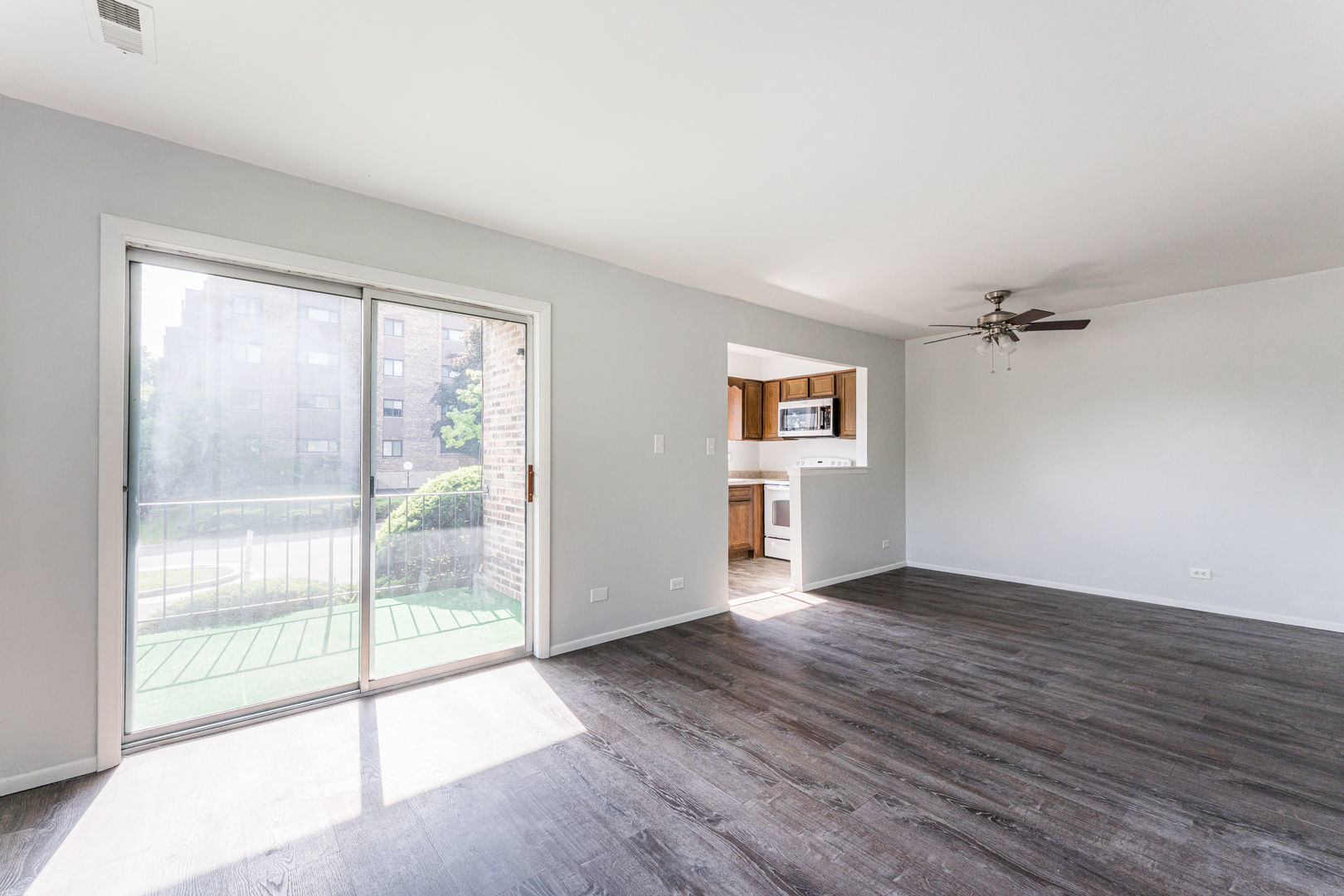 625 West Huntington Commons Road, Unit 106 Mount Prospect, IL 60056 - Photo 3 of 17 wooden floor in an empty room with a window