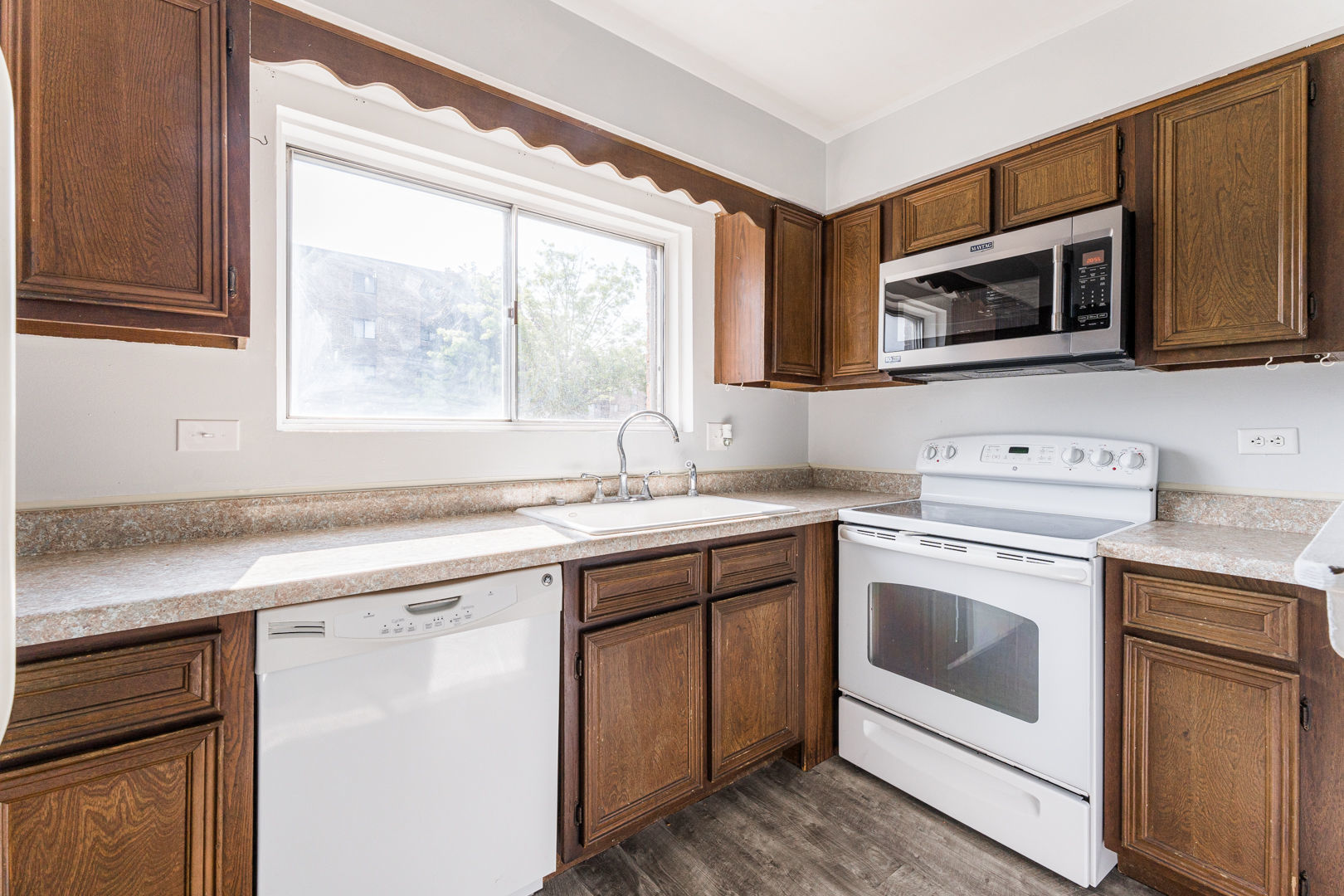 625 West Huntington Commons Road, Unit 106 Mount Prospect, IL 60056 - Photo 4 of 17 a kitchen with a stove microwave and sink