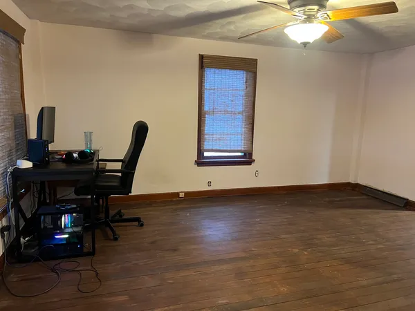 a view of a workspace with furniture and wooden floor