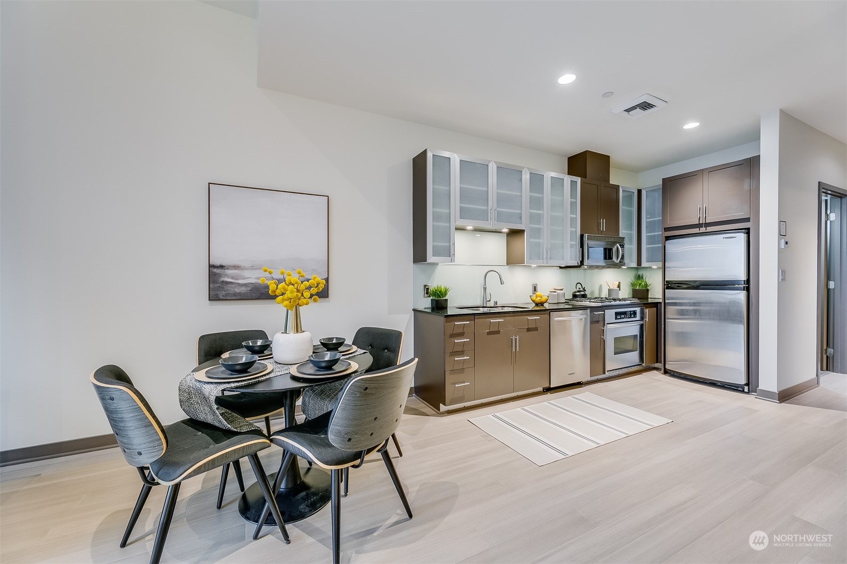 2033 2nd Avenue, Unit 101 Seattle, WA 98121 - Photo 17 of 37 a kitchen with granite countertop a sink cabinets and stainless steel appliances