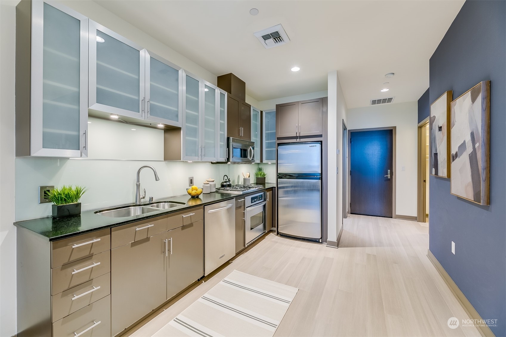 2033 2nd Avenue, Unit 101 Seattle, WA 98121 - Photo 18 of 37 a kitchen with stainless steel appliances granite countertop a refrigerator and a sink