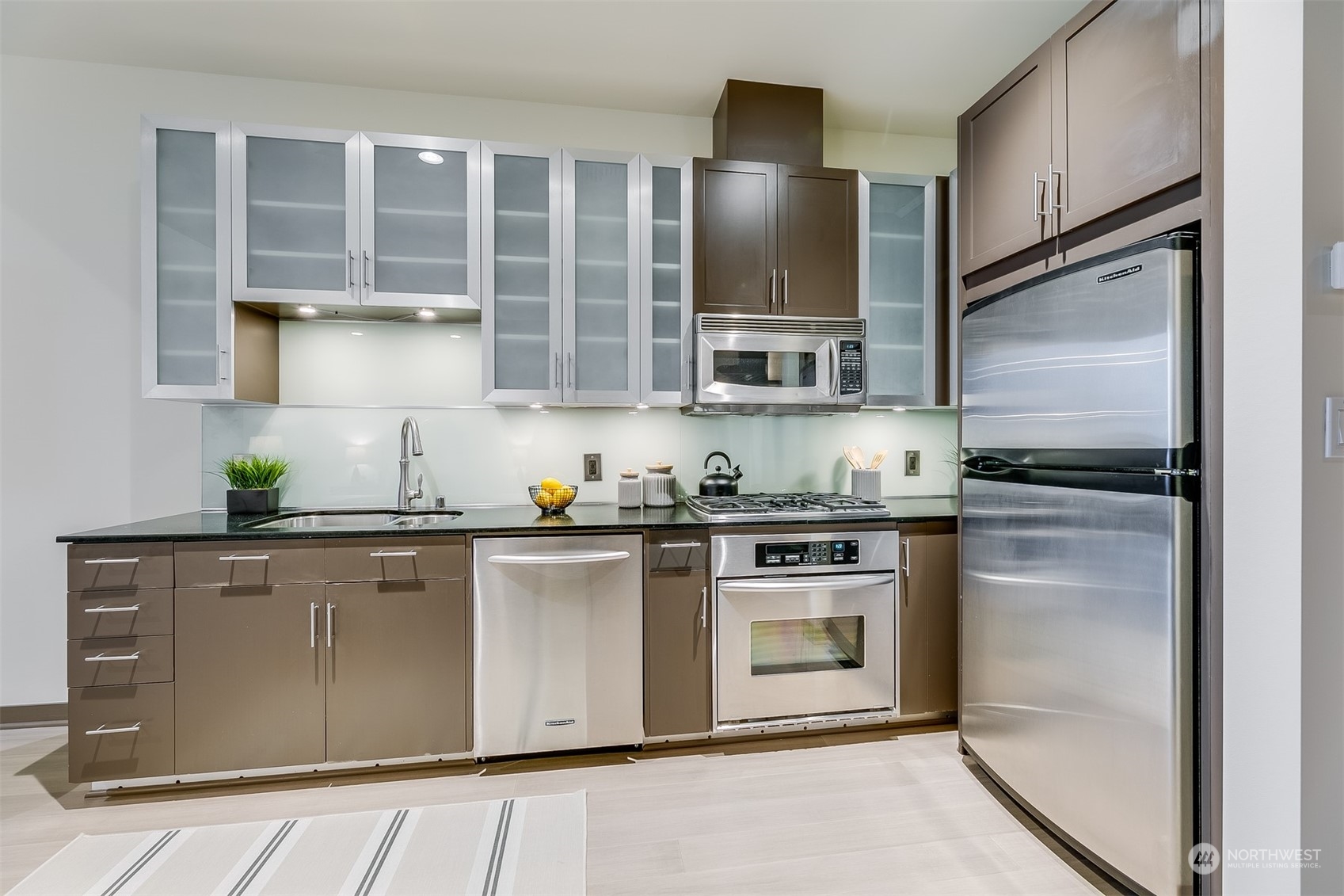 2033 2nd Avenue, Unit 101 Seattle, WA 98121 - Photo 19 of 37 a kitchen with stainless steel appliances granite countertop a stove a refrigerator and a sink