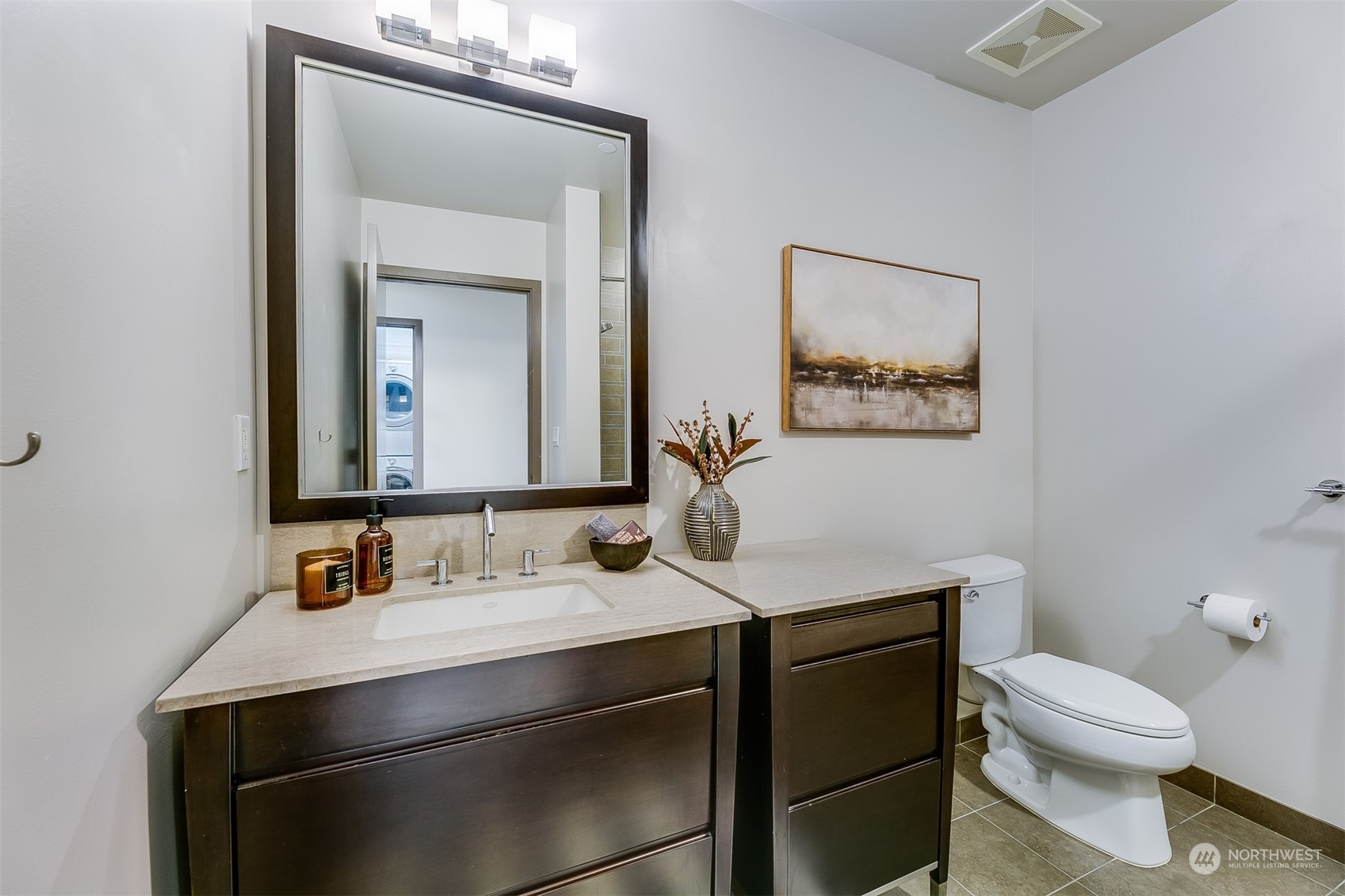 2033 2nd Avenue, Unit 101 Seattle, WA 98121 - Photo 21 of 37 a bathroom with a toilet sink vanity and mirror
