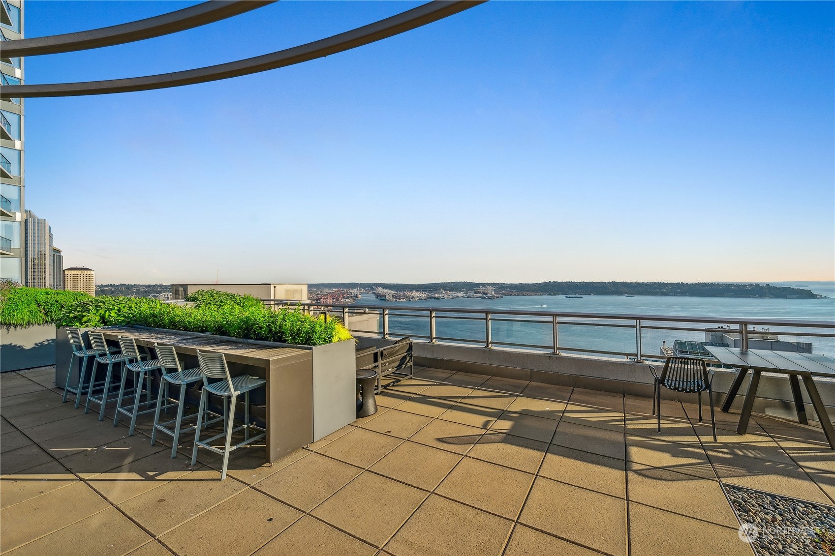 2033 2nd Avenue, Unit 101 Seattle, WA 98121 - Photo 27 of 37 a roof deck with table and chairs and potted plants