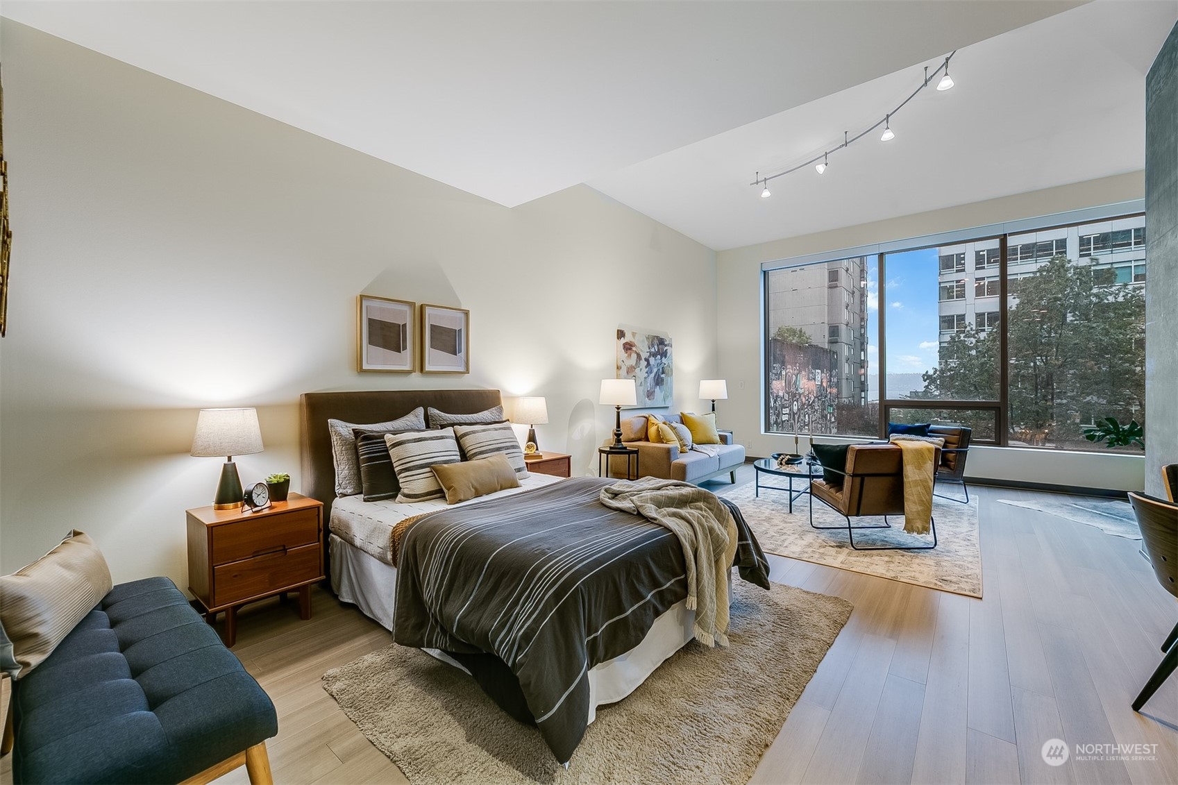 2033 2nd Avenue, Unit 101 Seattle, WA 98121 - Photo 7 of 37 a bedroom with a bed and glass walk in closet