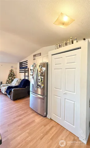 a room with a bed and a view of kitchen