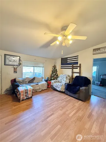 a living room with stainless steel appliances furniture and kitchen view