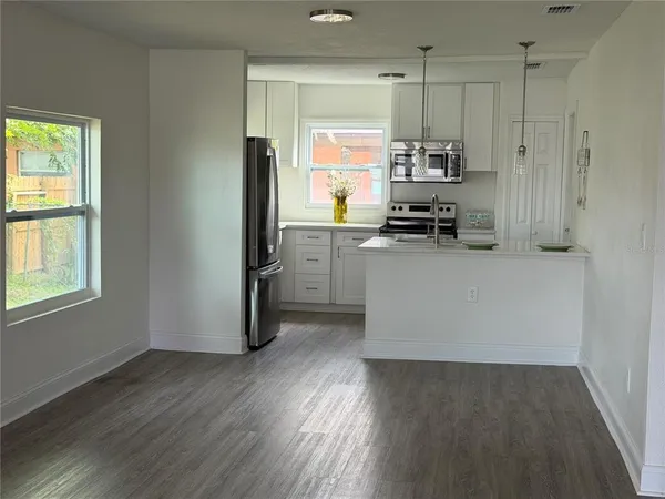a kitchen with stainless steel appliances a refrigerator and a stove top oven
