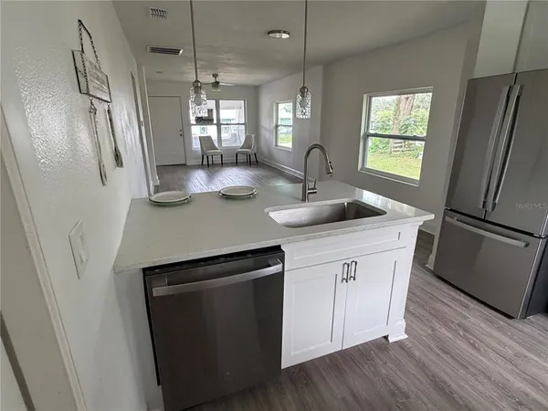 a kitchen with stainless steel appliances granite countertop a refrigerator a sink a stove a microwave and island
