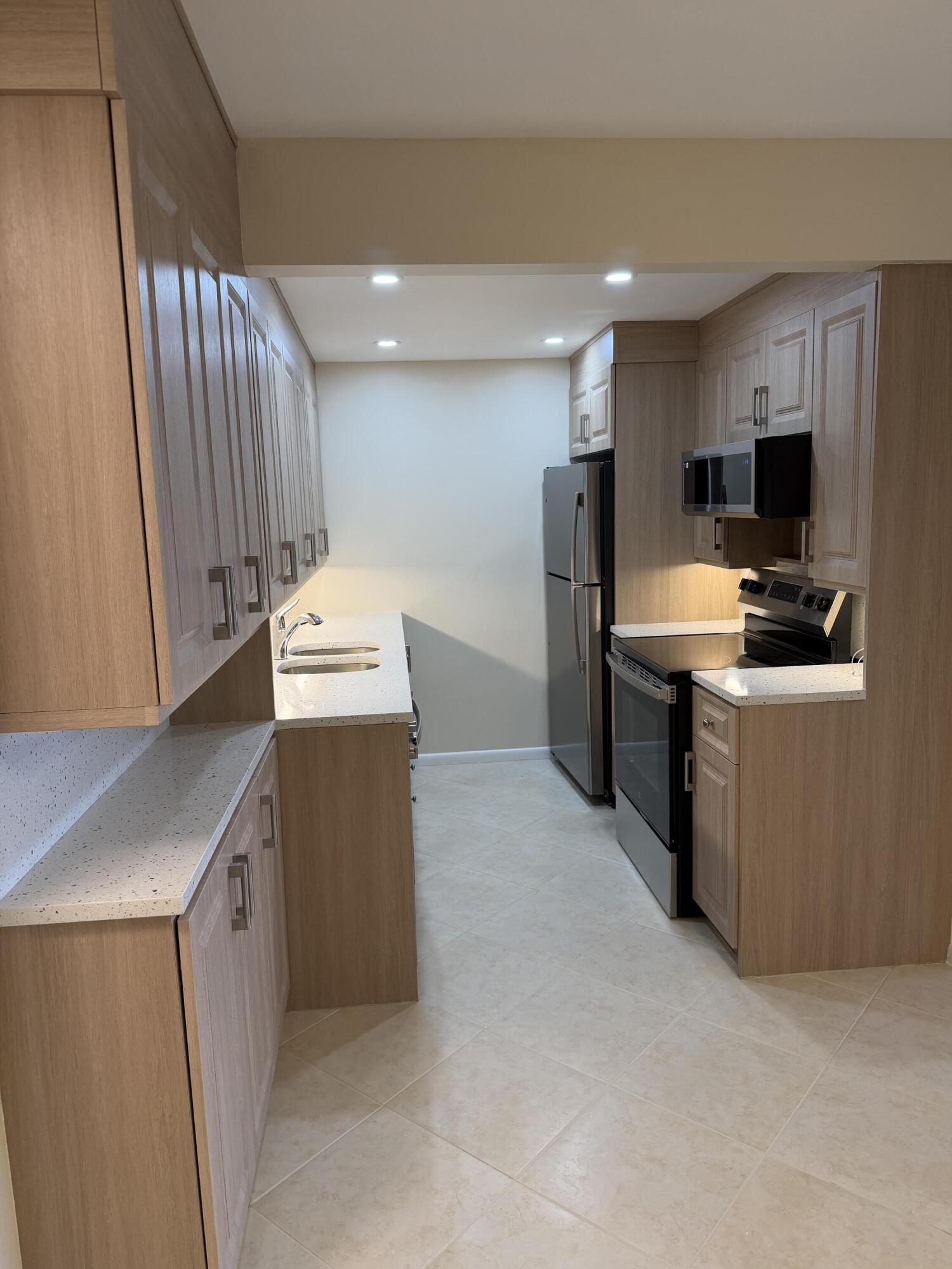 4067 Yarmouth C Boca Raton, FL 33434 - Photo 18 of 39 a work place with a flat screen tv a washer and dryer