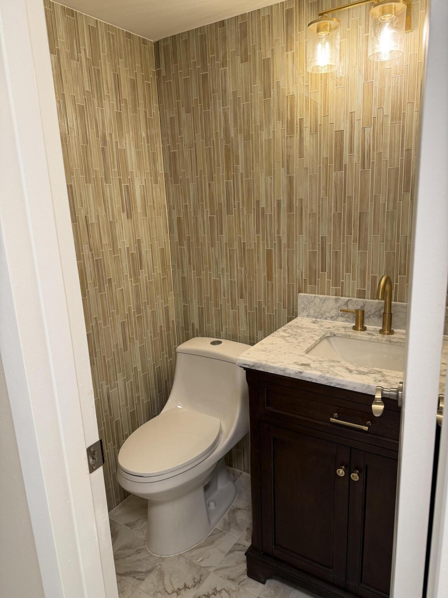 4067 Yarmouth C Boca Raton, FL 33434 - Photo 25 of 39 a bathroom with a granite countertop sink toilet and shower