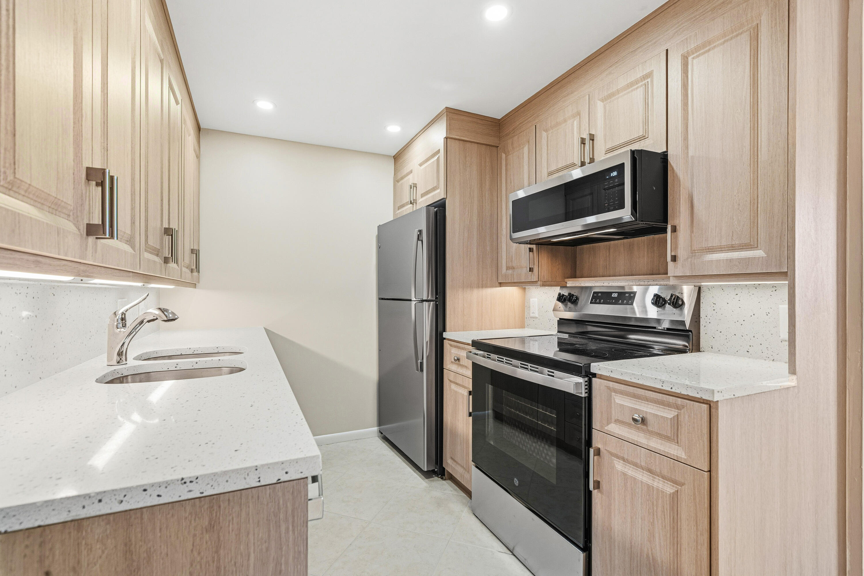 4067 Yarmouth C Boca Raton, FL 33434 - Photo 6 of 39 a kitchen with stainless steel appliances granite countertop a sink stove and refrigerator