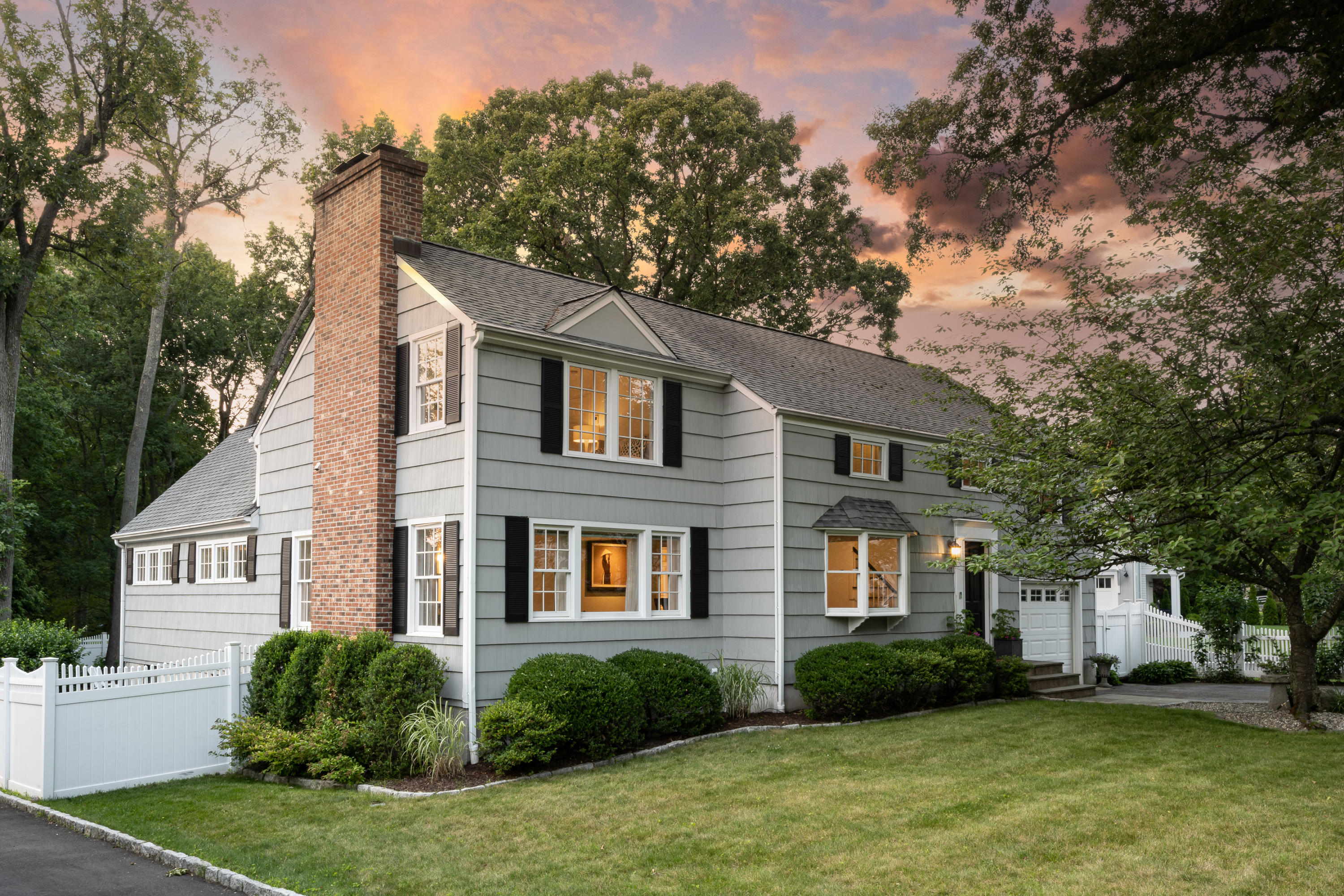 a front view of a house with a yard and trees