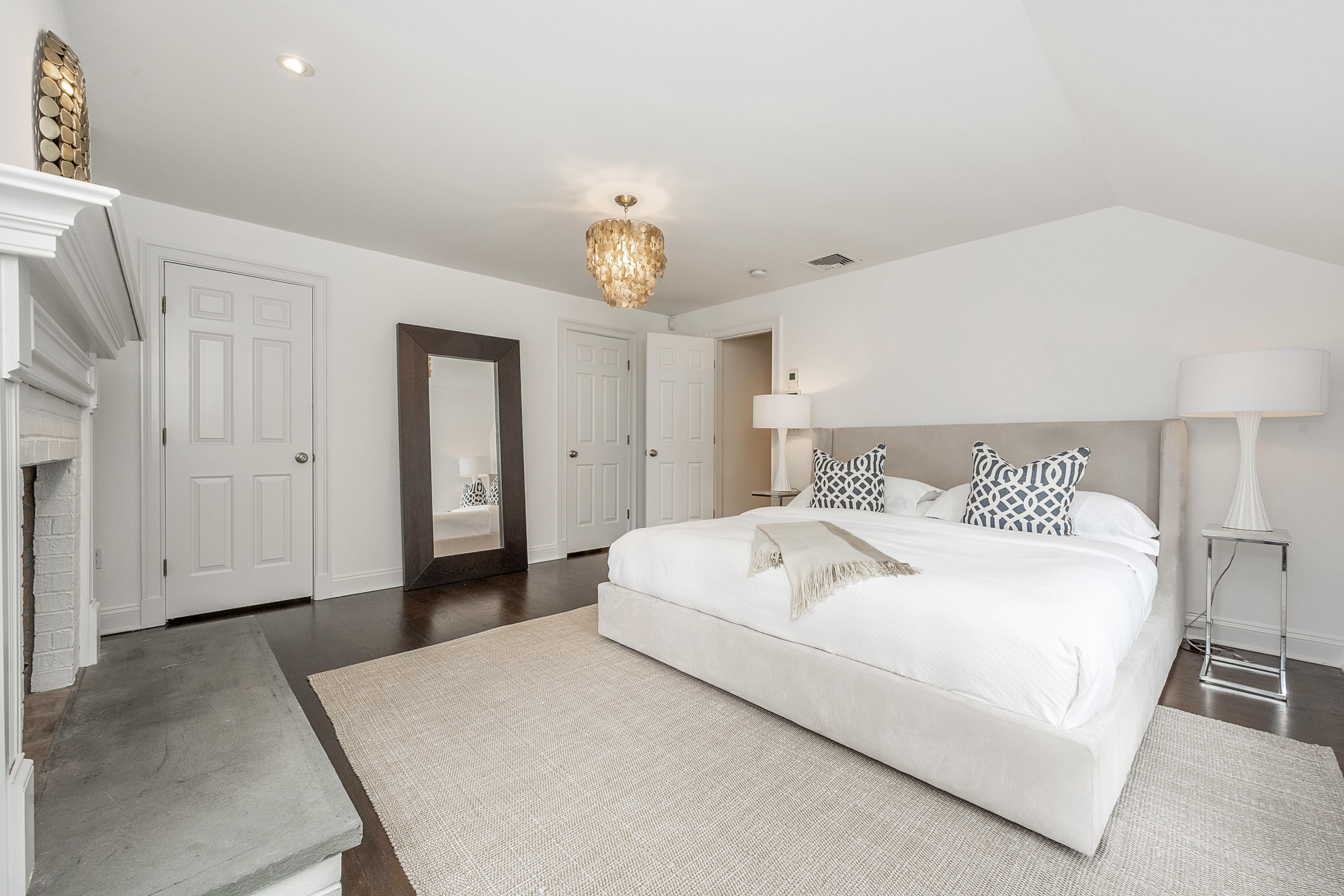 107 Hollow Tree Ridge Road Darien, CT 06820 - Photo 18 of 32 a bedroom with a bed and a chandelier