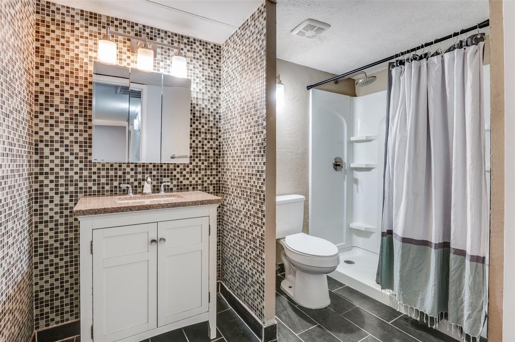 4859 Cedar Springs Road, Unit 144 Dallas, TX 75219 - Photo 9 of 14 a bathroom with a sink a toilet and shower