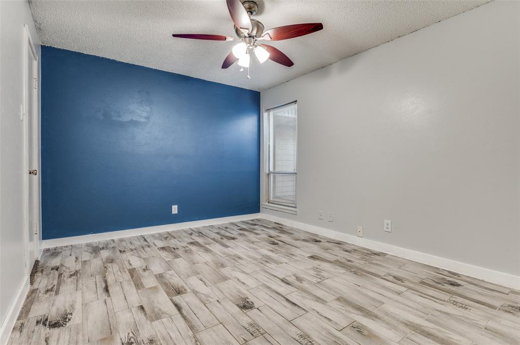 4859 Cedar Springs Road, Unit 144 Dallas, TX 75219 - Photo 10 of 14 a view of a big room with wooden floor and a chandelier fan