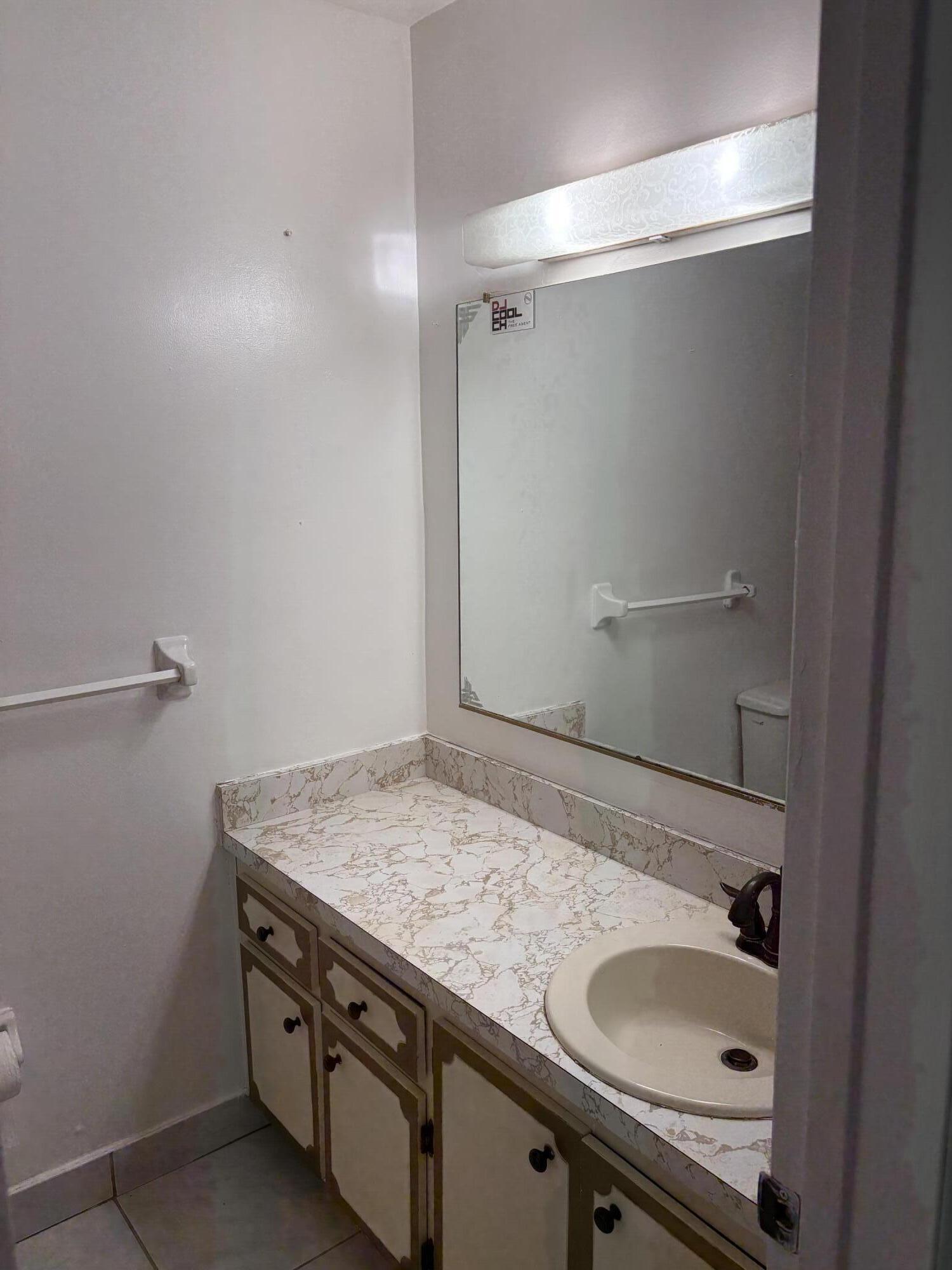 2801 Albatross Road Delray Beach, FL 33444 - Photo 11 of 14 a bathroom with a granite countertop sink and white cabinets
