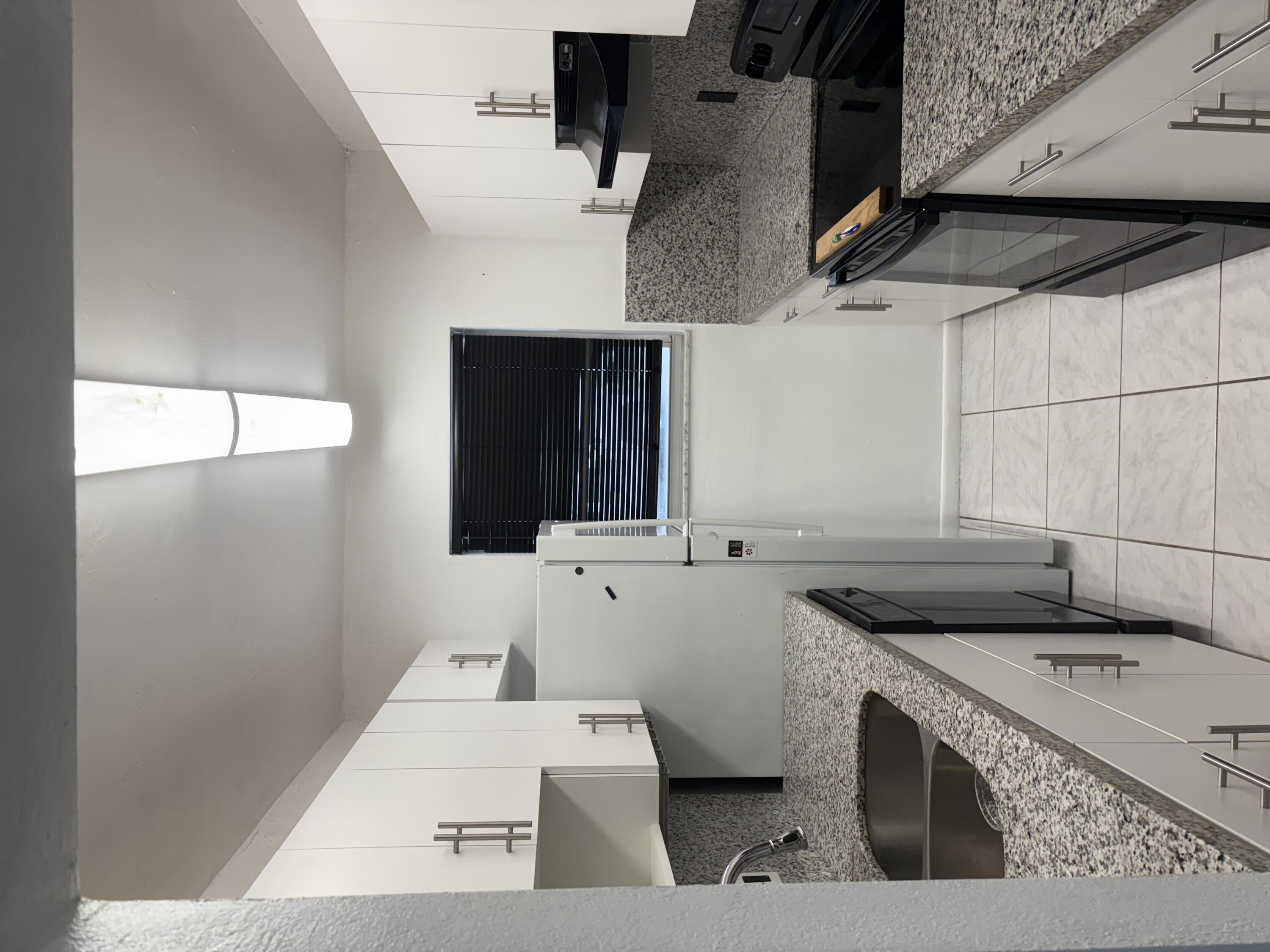 2801 Albatross Road Delray Beach, FL 33444 - Photo 3 of 14 a kitchen with stainless steel appliances granite countertop a sink stove and refrigerator