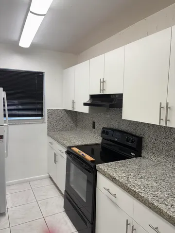 a kitchen with granite countertop a sink and a stove