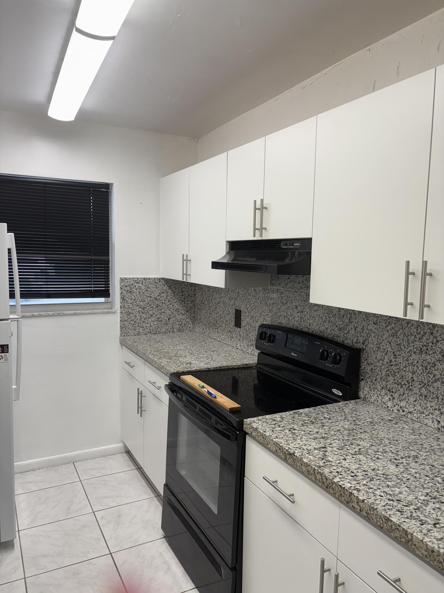 2801 Albatross Road Delray Beach, FL 33444 - Photo 4 of 14 a kitchen with granite countertop a sink and a stove