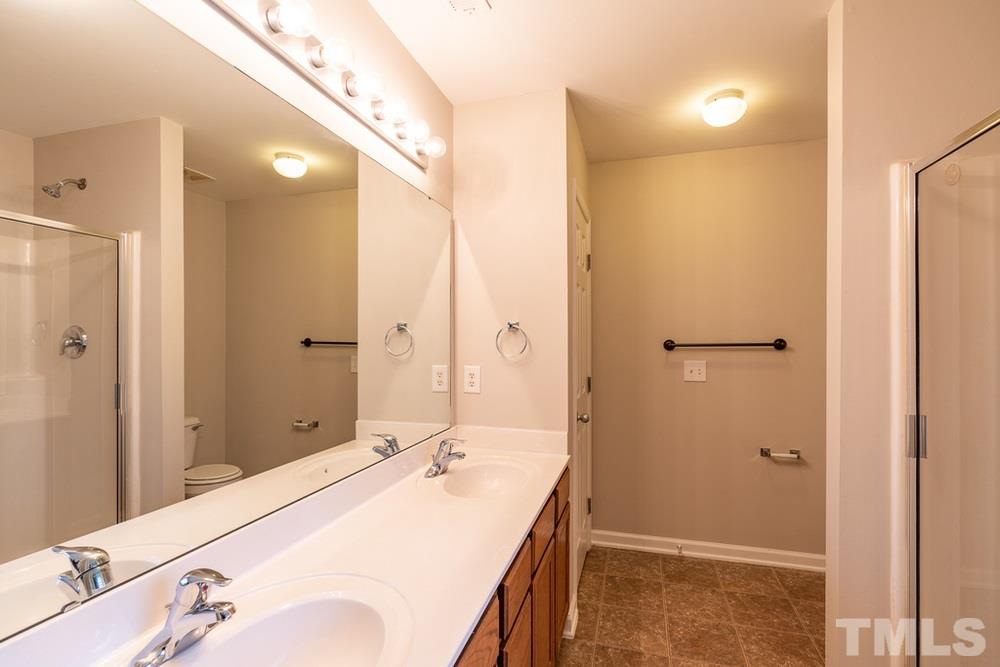 3513 Rendition Street Raleigh, NC 27610 - Photo 14 of 30 a bathroom with a sink a mirror and a shower