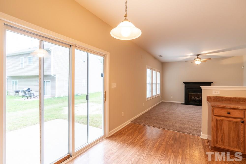 3513 Rendition Street Raleigh, NC 27610 - Photo 6 of 30 a view of a hallway with wooden floor and a kitchen