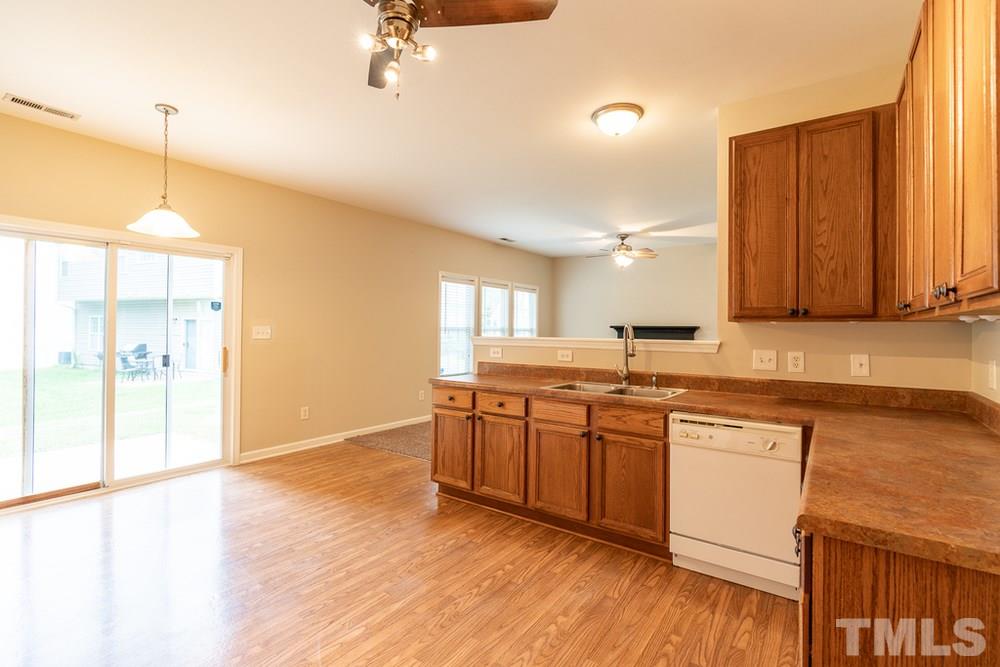 3513 Rendition Street Raleigh, NC 27610 - Photo 10 of 30 a kitchen with stainless steel appliances granite countertop a sink a stove a refrigerator and island with wooden floor