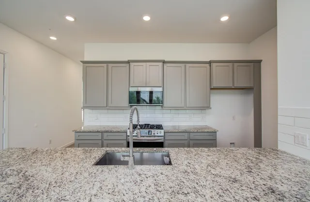 a kitchen with sink refrigerator and stove
