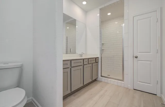 a bathroom with a granite countertop sink a toilet and a mirror