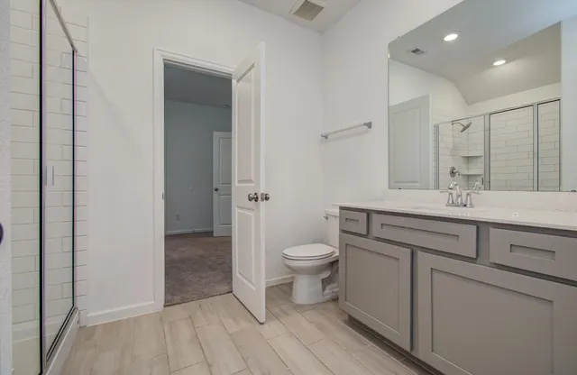 a bathroom with a toilet a sink and mirror