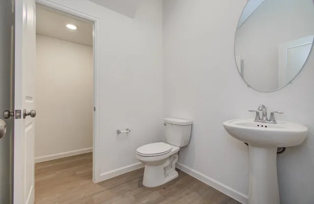 a bathroom with a sink toilet and a mirror