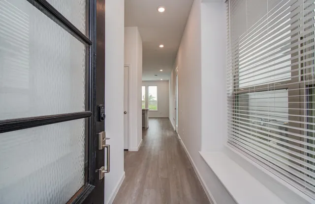 a view of a hallway with wooden floor and staircase