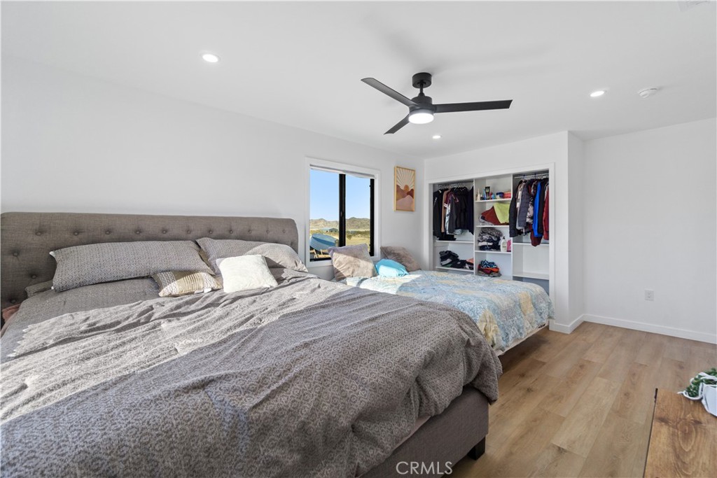 64654 Sun Mesa Road Joshua Tree, CA 92252 - Photo 17 of 25 a bedroom with a large bed and a chandelier
