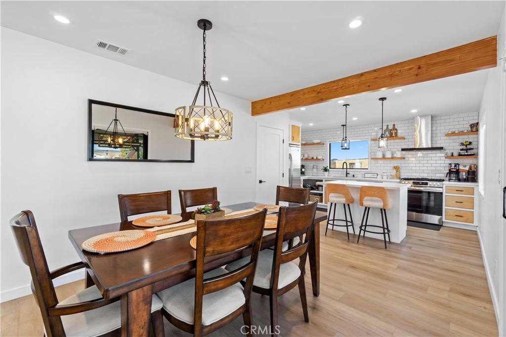 64654 Sun Mesa Road Joshua Tree, CA 92252 - Photo 6 of 25 a dining room with a table chairs and a kitchen view