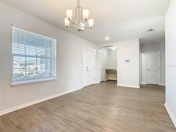 a kitchen with stainless steel appliances granite countertop a stove a sink and white cabinets with wooden floor