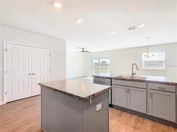 a view of a kitchen and an empty room