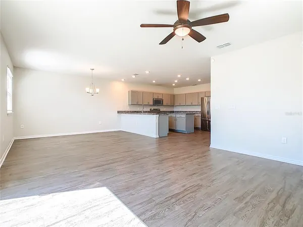 an empty room with a ceiling fan and window